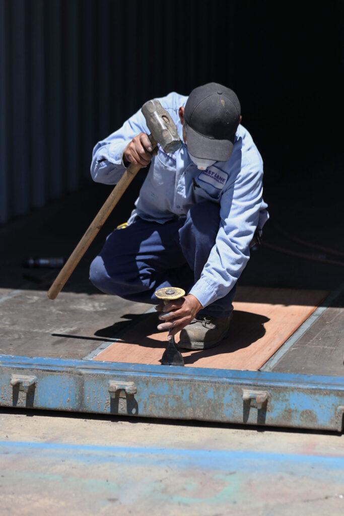 Repairing the flooring of a storage-class shipping container to certify it as cargo-worthy