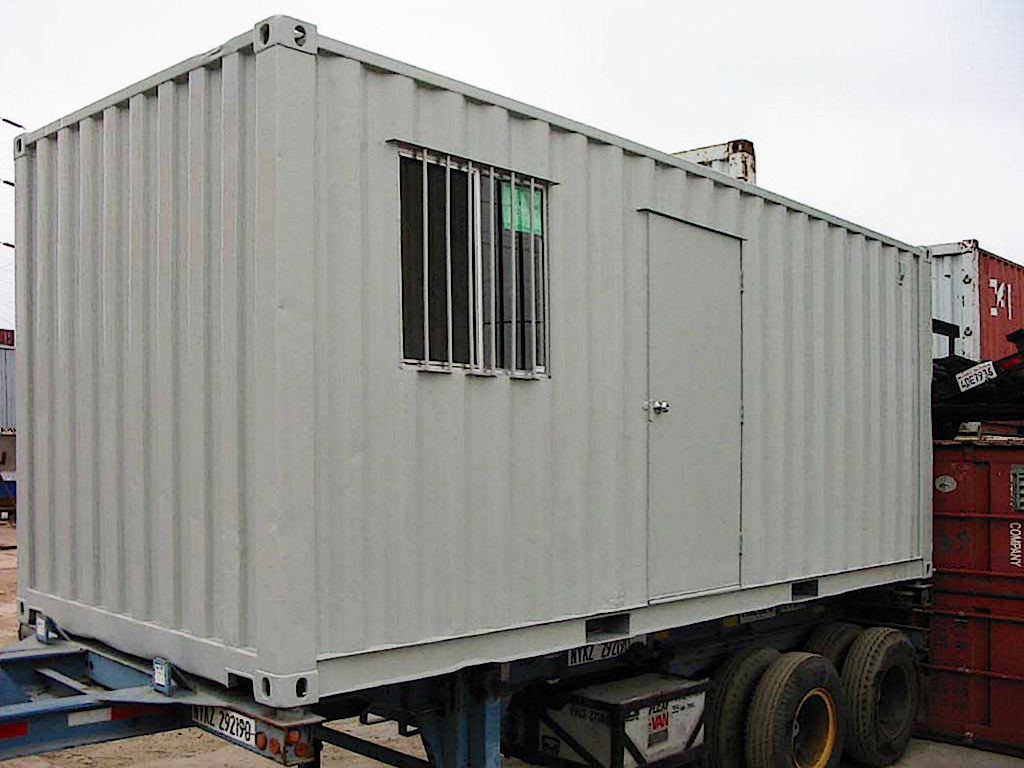 Modified shipping container with sliding window, security bars, and a personal door installed