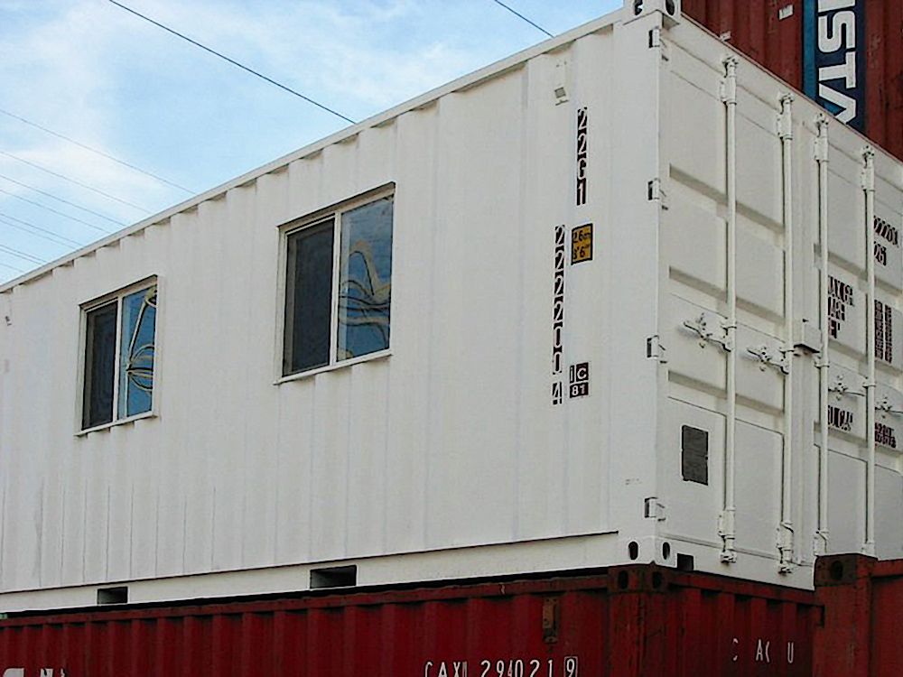 Modified shipping container with sliding windows installed